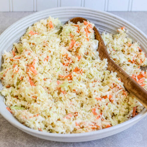 traditional creamy cabbage in a bowl with a wooden spoon