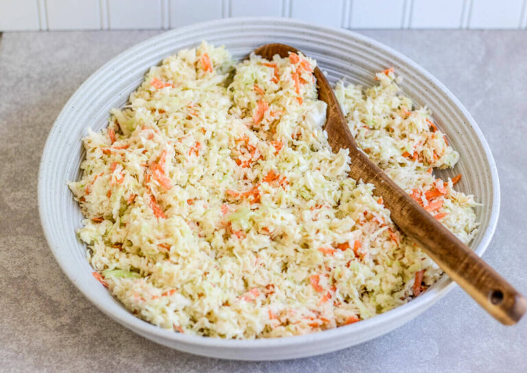 traditional creamy cabbage in a bowl with a wooden spoon